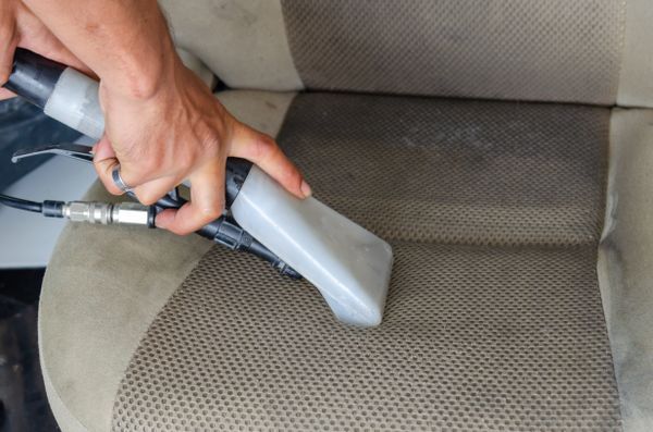 Interior car seat being vacuumed