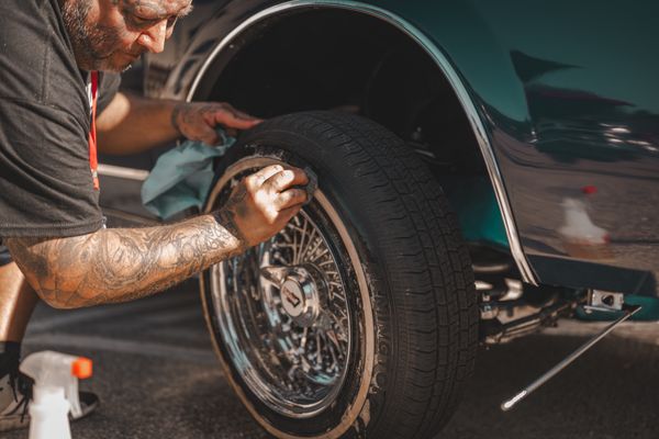 Car tyre and rim being hand-cleaned